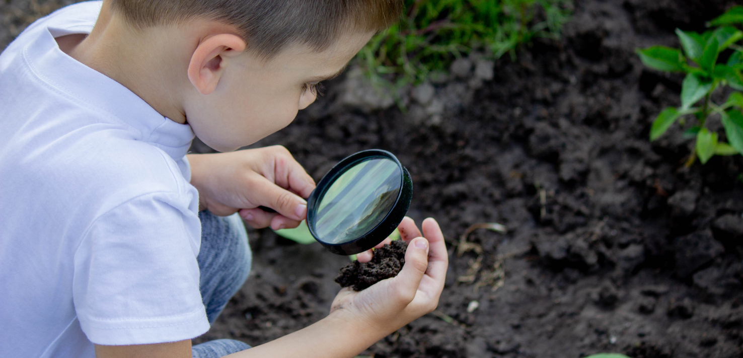 Child studying the soil for a soil investigation